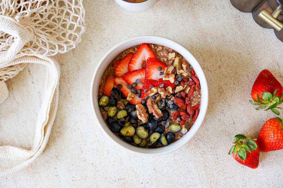 Chocolate overnight oats topped with strawberries, blueberries, walnuts, goji berries, and chocolate chips in a glass jar