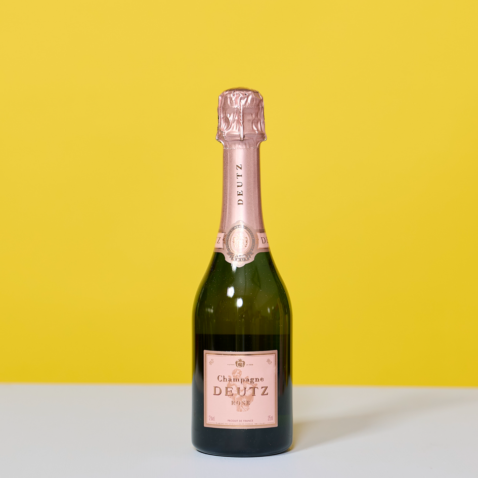 Deutz Champagne Brut Rosé in kleiner Falsche vor gelbem Hintergrund