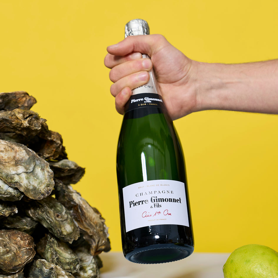 Pierre Gimonnet & Fils Champagne Cuis Premier in großer Flasche neben frischen Austern und Zitrone