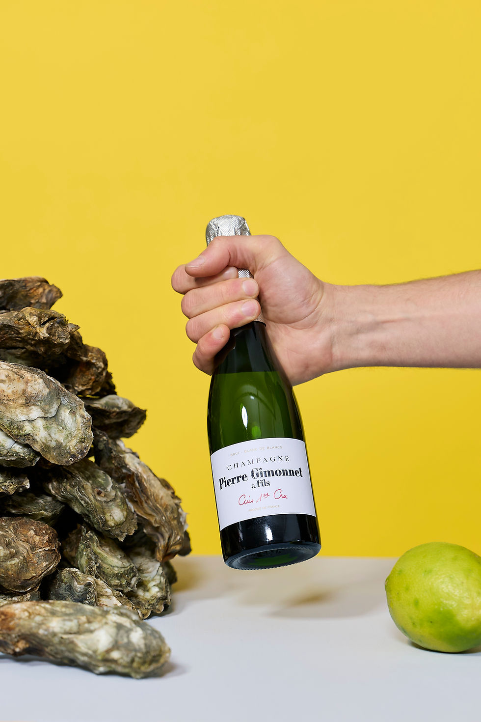 Pierre Gimonnet & Fils Champagne Cuis Premier in kleiner Flasche neben frischen Austern und Zitrone