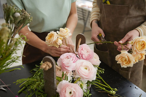 Close up of beautiful flower composition with roses and peonies on table in florist worksh