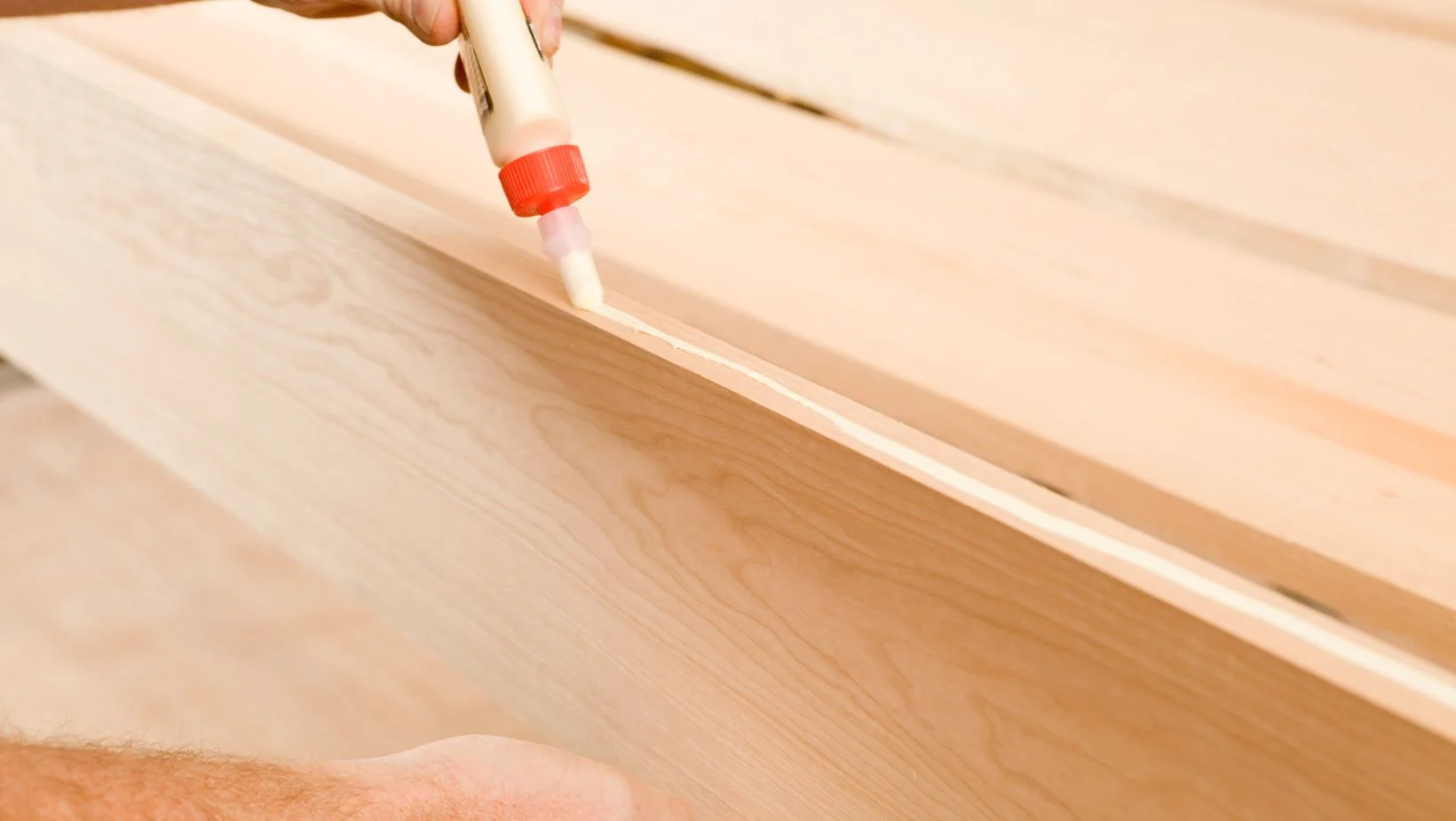 Carpenter applying Wood Glue to a Board