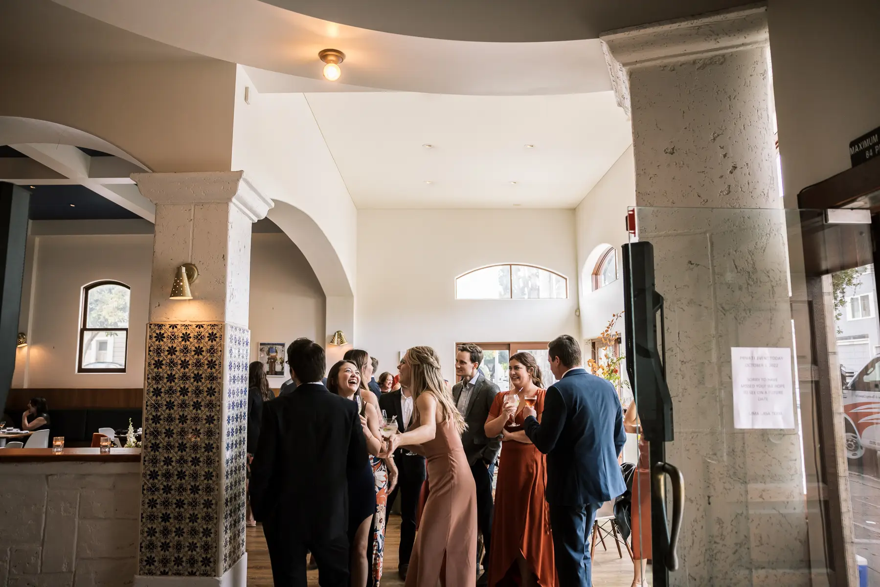 wedding guests mingling during cocktail hour inside san francisco restaurant reception space