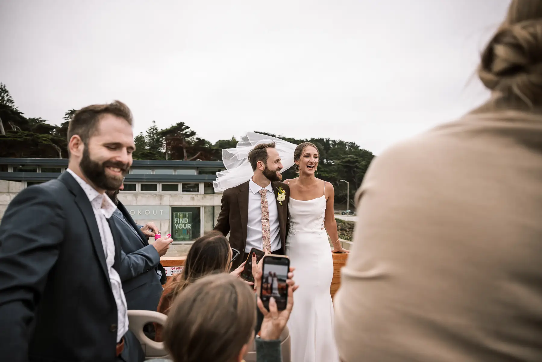 bride and groom smiling on open top bus with wedding guests in san francisco