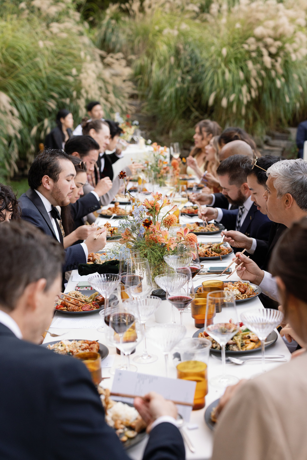 Guests enjoying dinner at long outdoor reception tables at Olive Oaks wedding venue in Sebastopol, California.