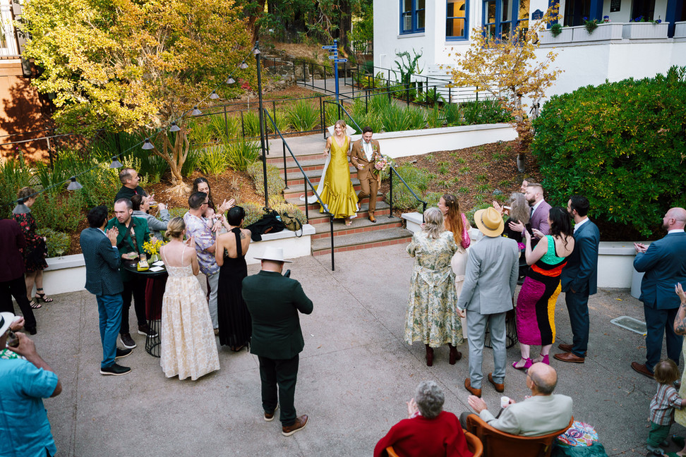 Newlywed couple enters cocktail hour in the courtyard at Stavrand. 