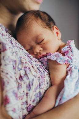 Newborn baby sleeping on shoulder at home photo shoot.