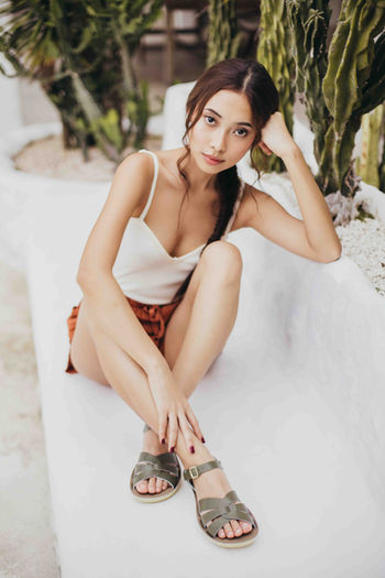 Woman in green sandals on bench, lifestyle product photography