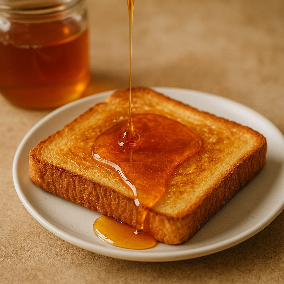 דבש נוזל על טוסט זהוב על צלחת לבנה, כשברקע צנצנת דבש מונחת על משטח בגוון בז'. סצנה חמה ומזמינה.