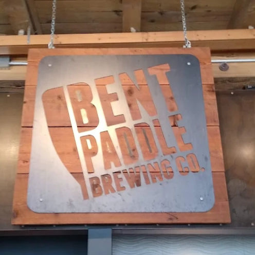 A metal sign of Bent Paddle Brewing's logo