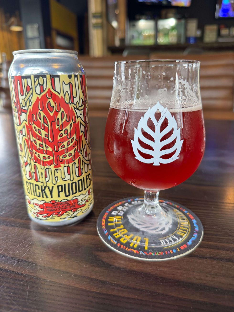 Photo of a glass and can of Sticky Puddles Cherry Cheesecake.