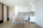 Modern minimalist kitchen and dining interior with custom cabinetry and kitchen island