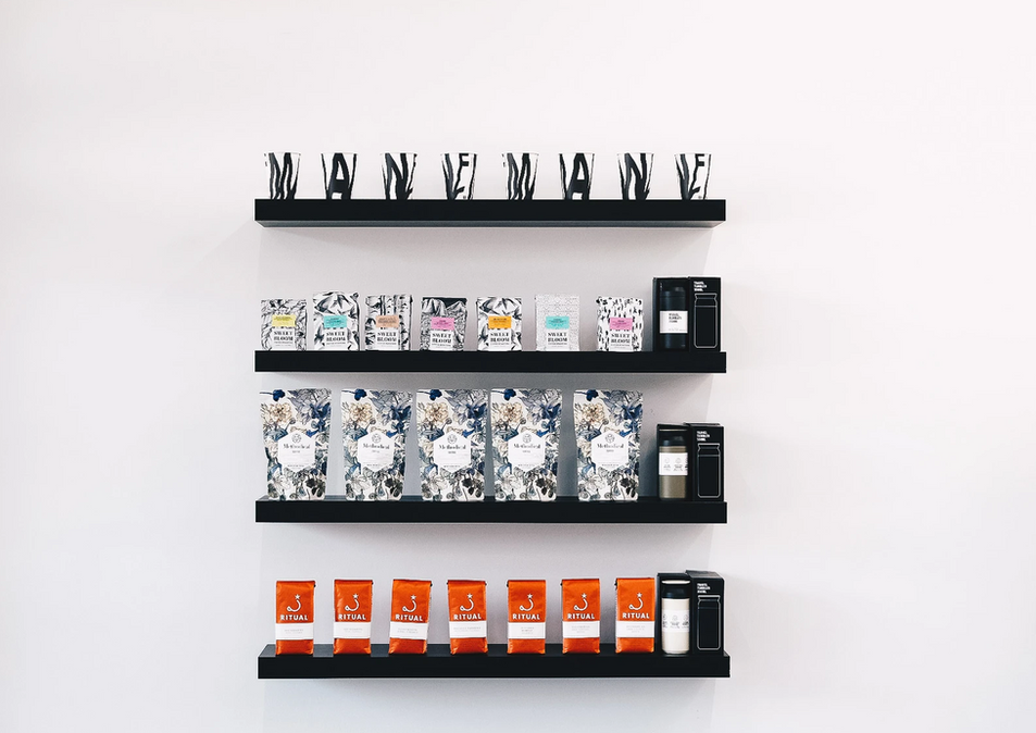 Mane Coffee product display on three black shelves