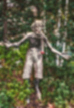 bronze coloured statue of a satyr in a garden
