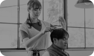 悩みスタイリストが男性の髪を切る様子