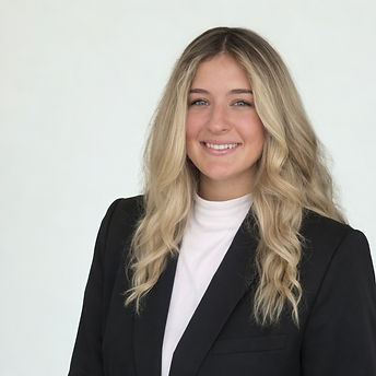 Professional headshot of a smiling woman with long blonde hair wearing a black blazer over a white top against a neutral background
