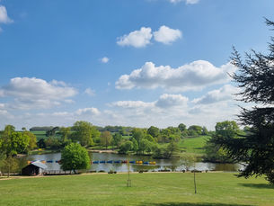 Grassland with a lake and open fields beyond