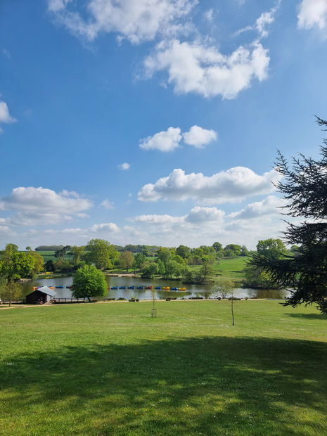 Grassland with a lake and open fields beyond