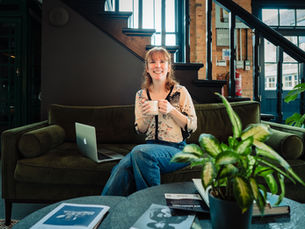 A woman sitting on a sofa with a cup of tea