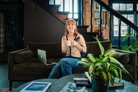 A woman sitting on a sofa with a cup of tea