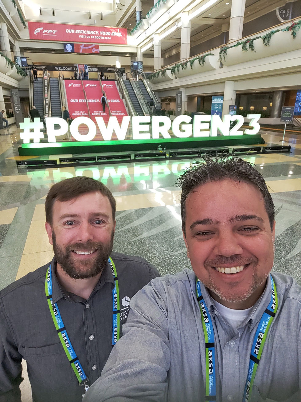 Men in front of PowerGen23 sign