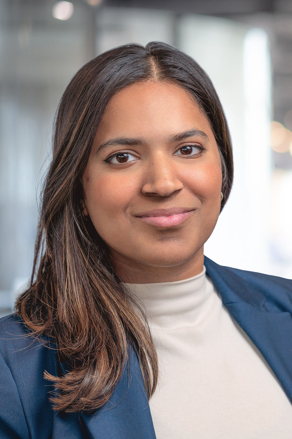 Corporate headshot of a female professional photographed in a Toronto office with soft lighting and a blurred background.