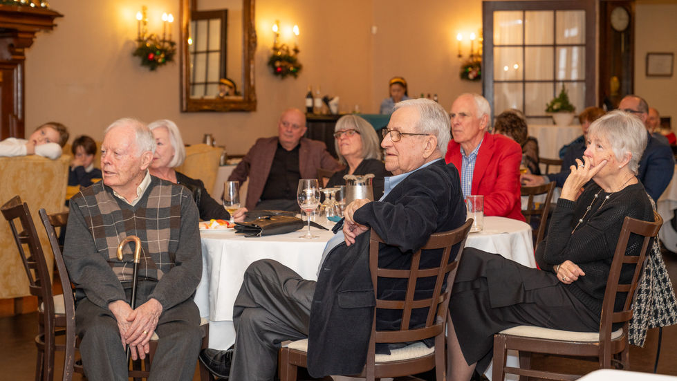 Guests watching a slideshow from their tables during a milestone birthday celebration in Toronto.