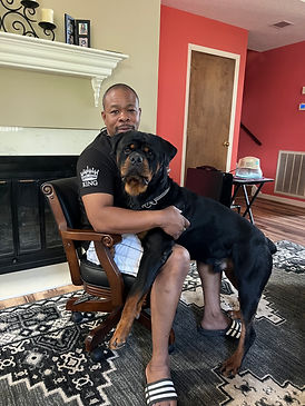 Picture of Lincoln a large and lean Rottweiler with his owner