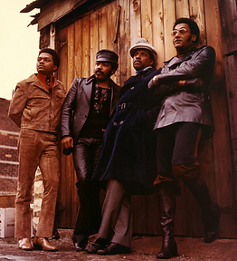 The Four Tops pose together in front of a wooden wall; four tops music.