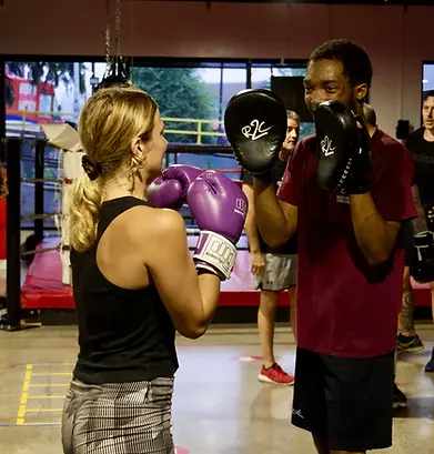 2 jeunes personnes durant un cours de boxe