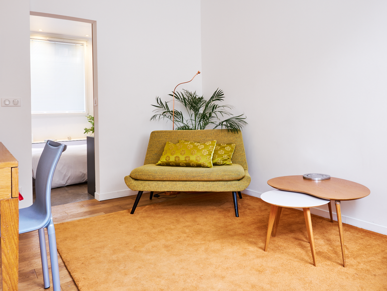 Salon lumineux avec fauteuil design dans un studio Airbnb moderne à Paris