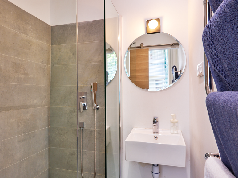 Salle de bain moderne avec douche dans un studio Airbnb à Paris