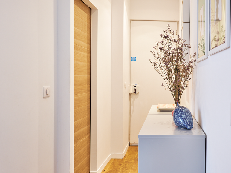 Vue de l’entrée et du couloir d’un appartement Airbnb moderne à Paris