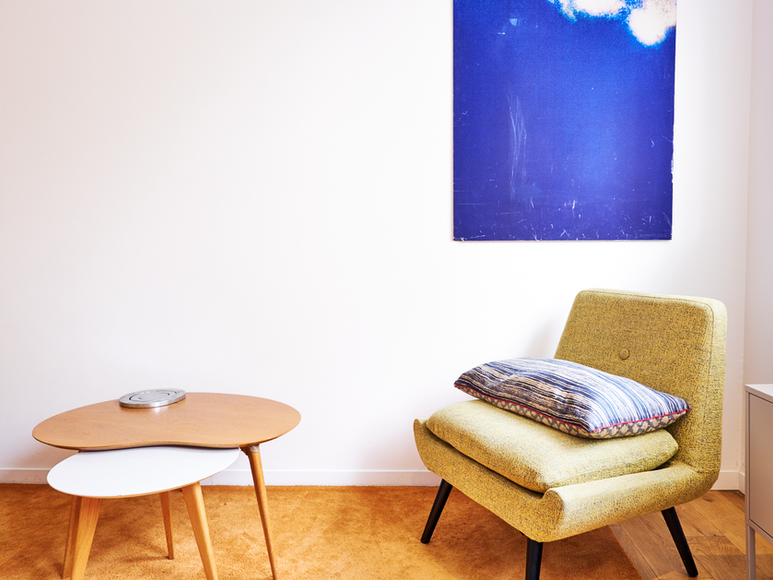 Fauteuil design et décoration murale dans un studio Airbnb contemporain