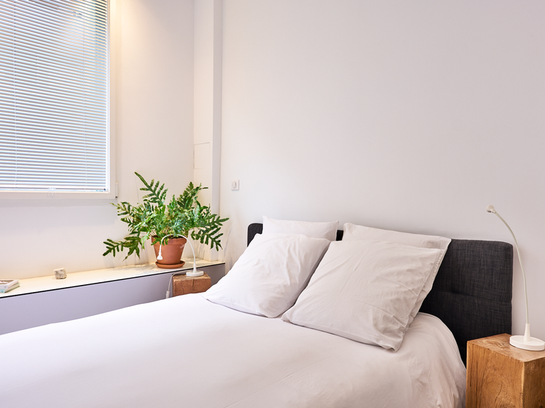 Lit double avec lumière naturelle dans une chambre Airbnb à Paris