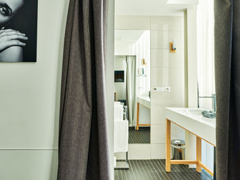 Vue de la salle de bains depuis la chambre avec lavabo et miroir