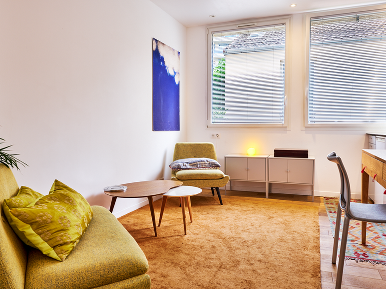 Vue intérieure d’un appartement Airbnb avec lumière naturelle et mobilier moderne