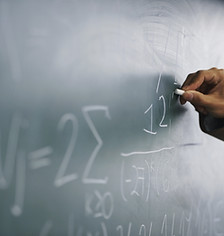 Teacher Writing a Formula on a Blackboar