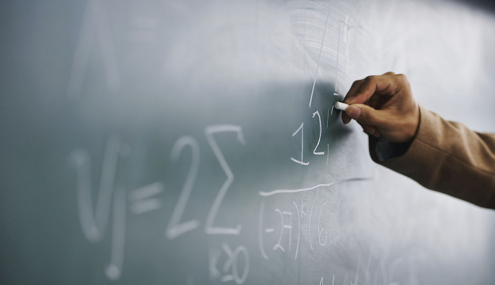 Teacher Writing a Formula on a Blackboard