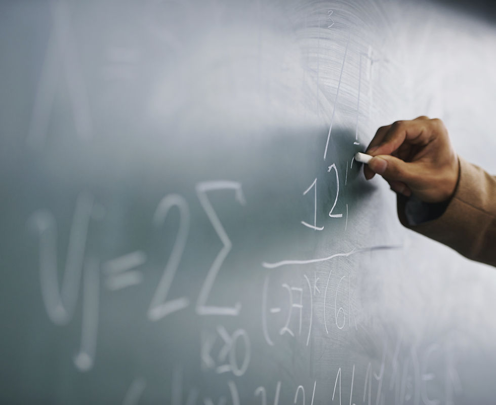 Teacher Writing a Formula on a Blackboard