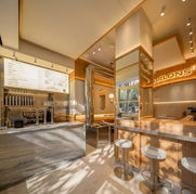 Interior de Parlon's, un espacio luminoso con barra y mesas con taburetes.