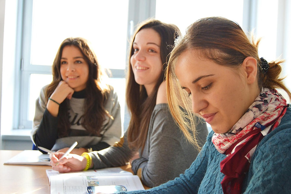 3 estudantes universitárias reunidas em sala de aula