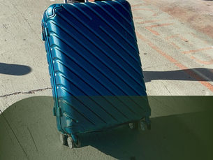 Person rolling a blue suitcase