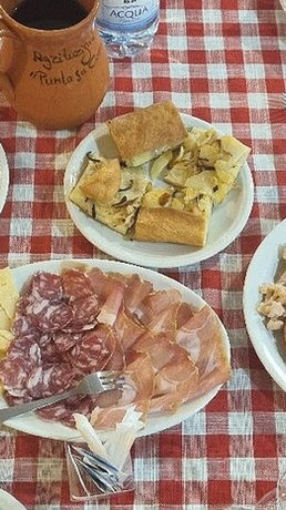 Tavolo con antipasti misti su tovaglia a quadri rossi