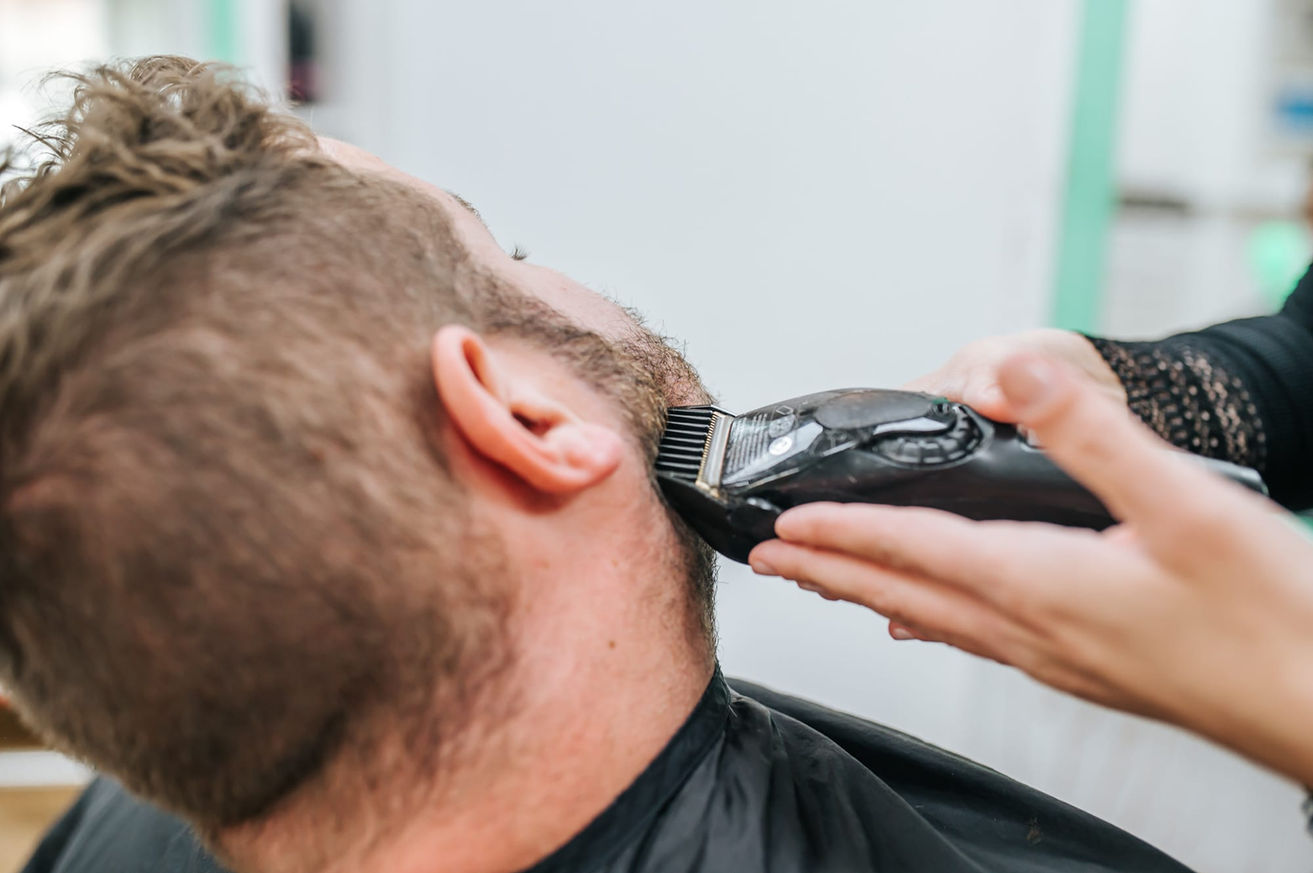Herren wird im Friseursolan der Bart getrimmt