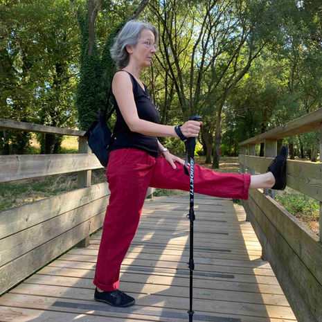 sur un pont de bois, Cath étire l'arrière de sa jambe