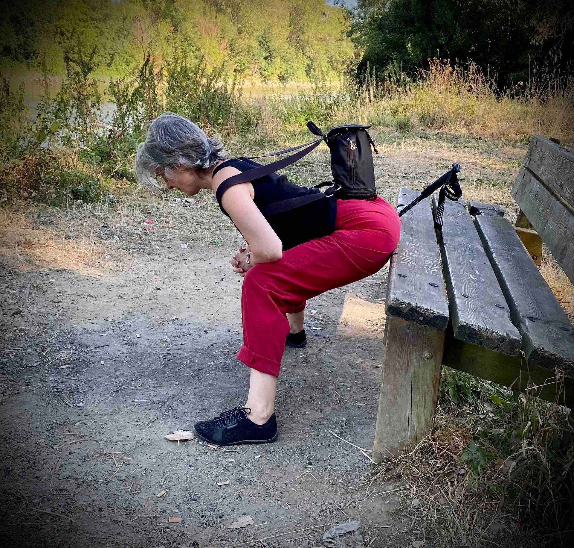 sur un ban de bois, Cath étire ses hanches
