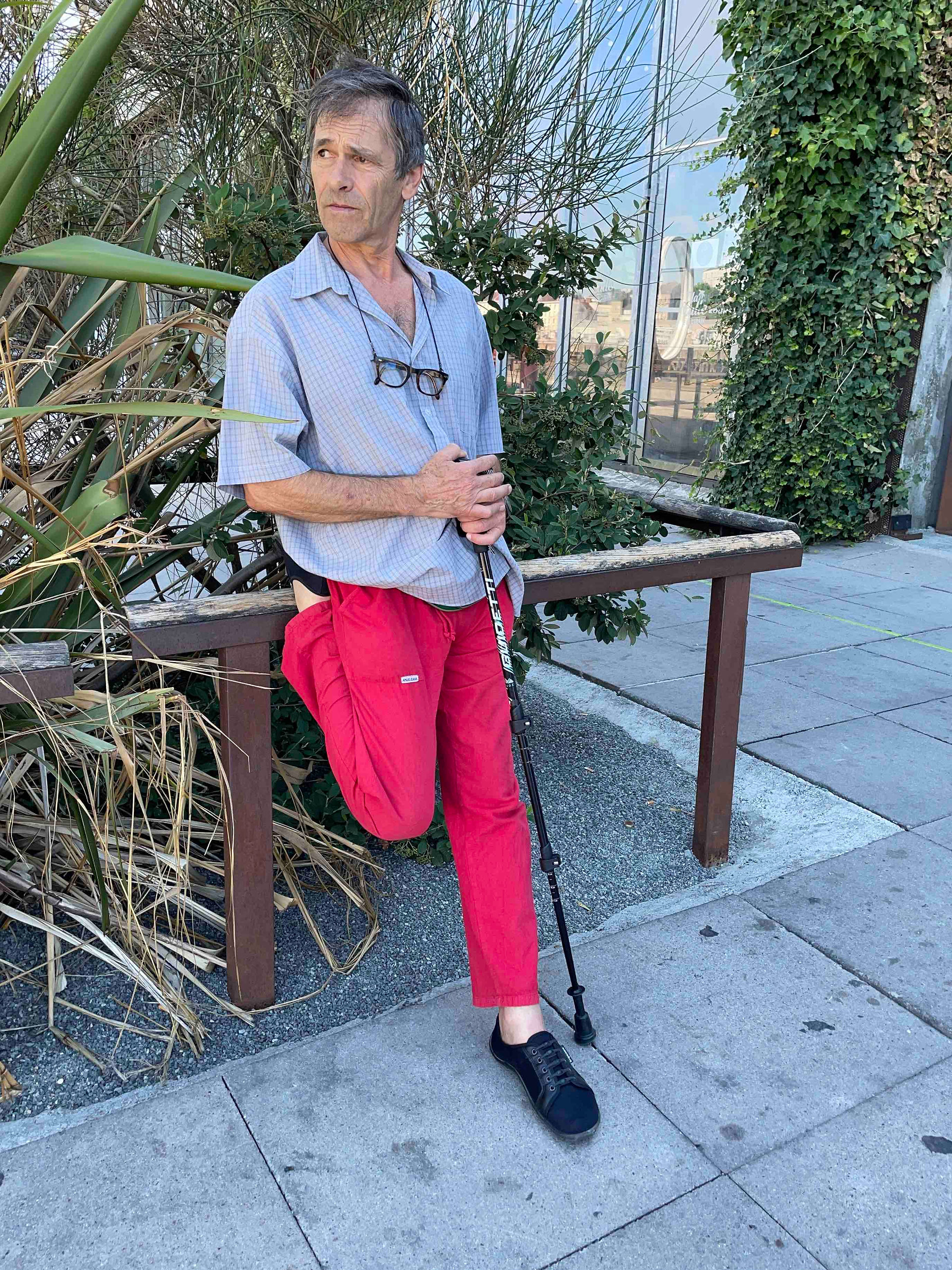 Sur une rambarde Serge étire son quadriceps