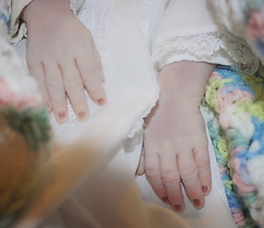 Baby's hands in white garment