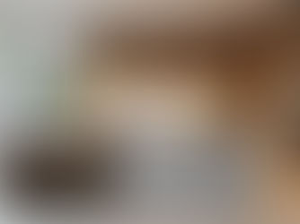 Photorealistic image of a 2025-inspired minimalist kitchen in Central NJ featuring a quartz waterfall island, wood cabinetry, integrated appliances, and large glass doors with natural lighting.